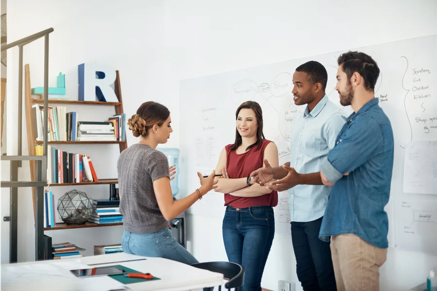 A small team collaborating around a whiteboard